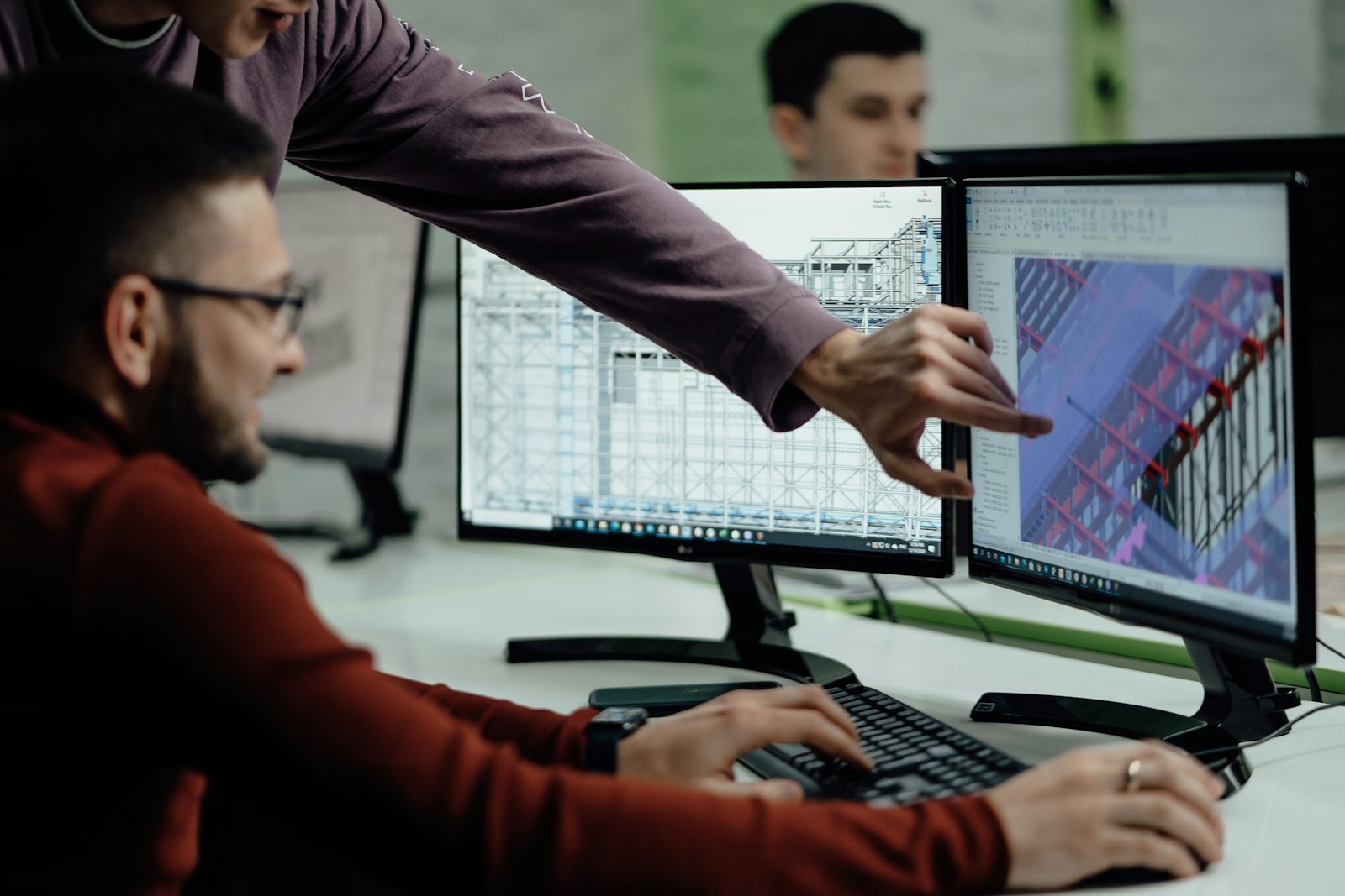 Engineers reviewing CAD designs on screen